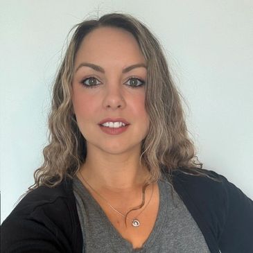 Woman with wavy hair smiling at the camera.