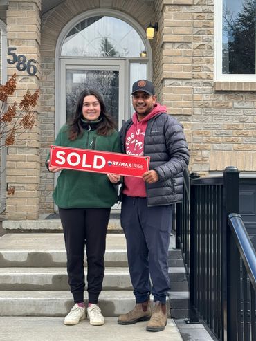 Couple holding something in front of their house