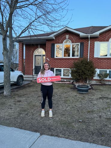 a person holding something in front of their house