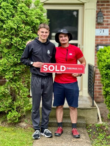 Couple holding something in front of their house