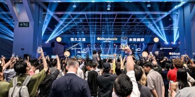 比特币亚洲活动现场，人群高举手机。