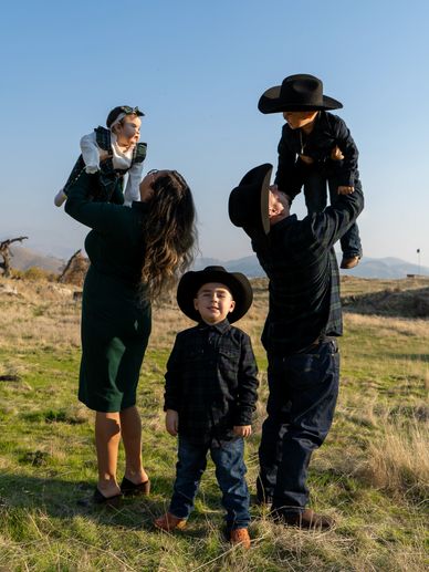 Family dressed in western attire enjoying a sunny day outdoors.