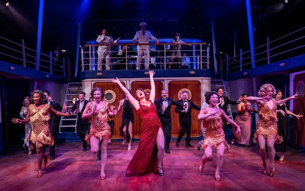 A lively theatrical performance with dancers and singers on stage.
