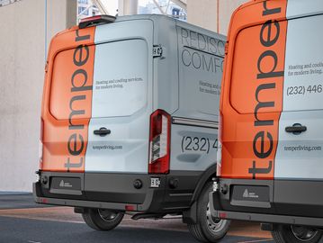 Two orange and white Temper living service vans parked closely together.