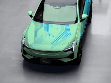 Top view of a green electric car with blue circuit patterns on the hood.