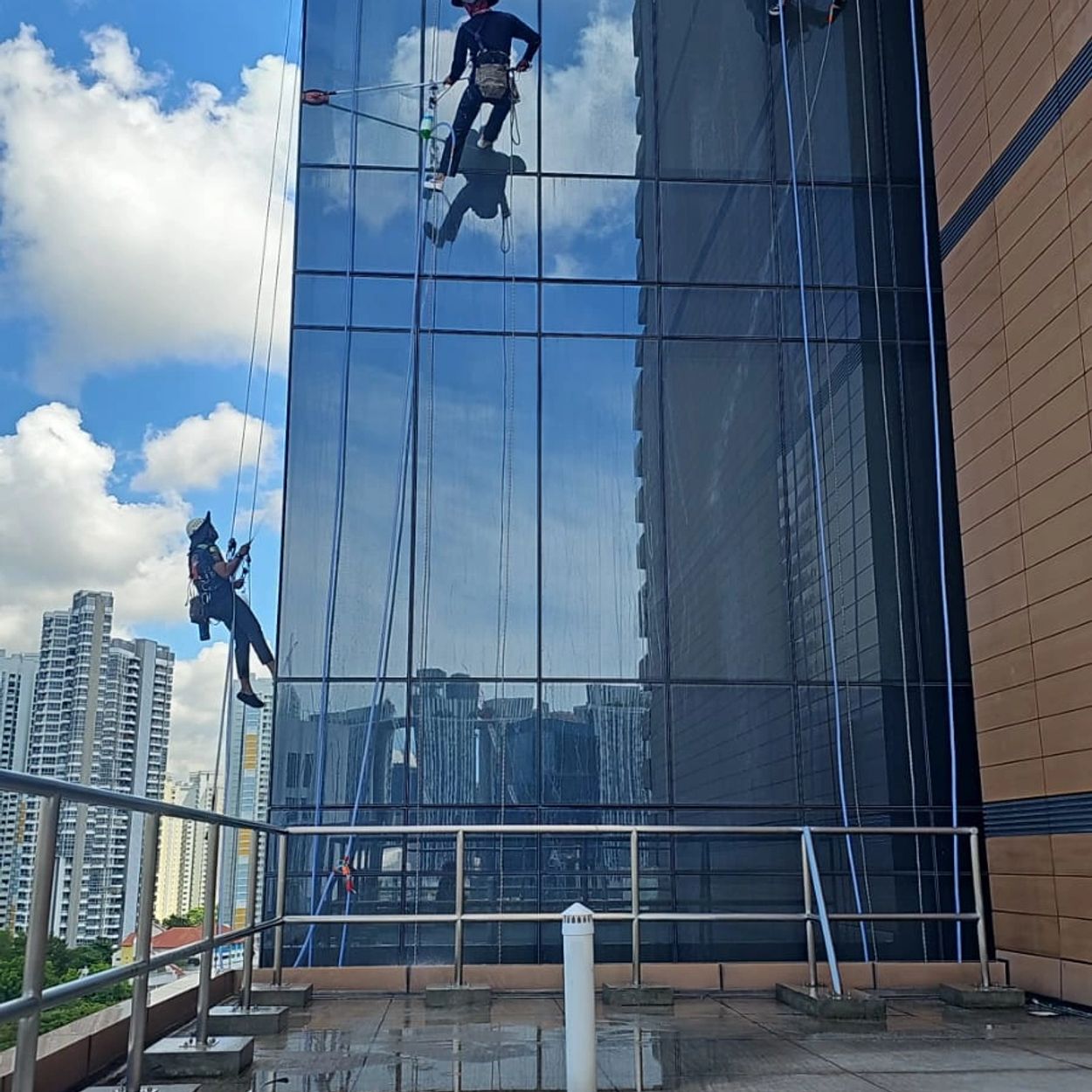 Rope access technicians flushing down windows on high rise facade