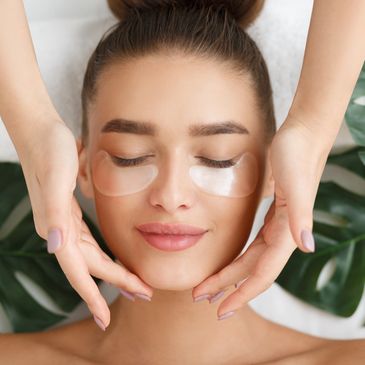 A nail technician is doing a facial service to a customer. 