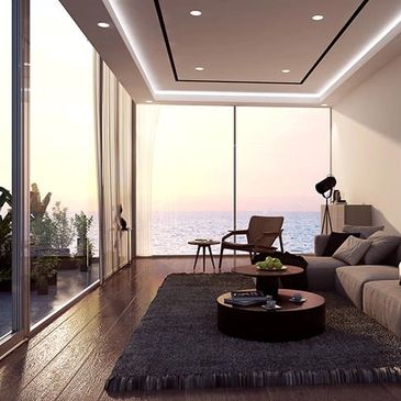 Modern living room with ocean view at sunset.