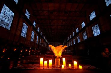 Dimly lit room with candles and feather centerpiece.