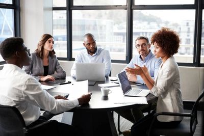 Diverse team engaged in a serious business meeting around a table.