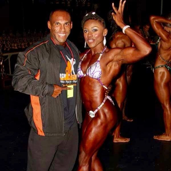 Female bodybuilder posing with a man at a bodybuilding event.