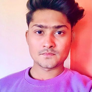 Young man with styled hair wearing a purple sweater.