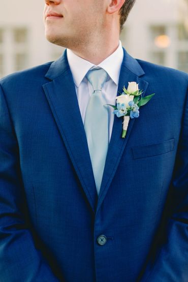 Man in a blue suit with a boutonniere.