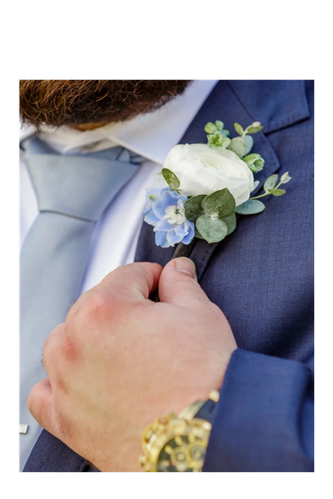 white ranunculus with light blue delphinium boutonniere