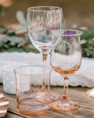 colored glassware on wooden wedding reception table