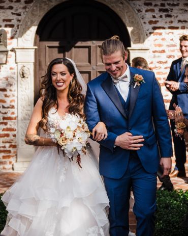Happy bride and groom walking together after wedding ceremony.