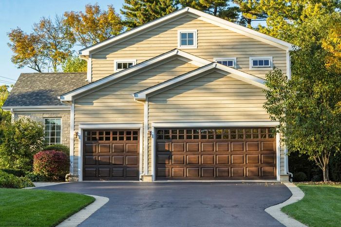 Modern house with two wooden garage doors and well-maintained driveway.