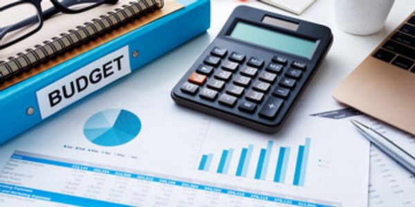 Calculator, budget binder, and financial charts on a desk.