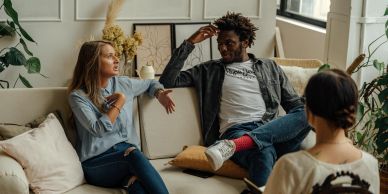 Three friends casually chatting in a cozy living room.