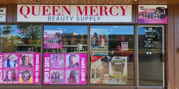 Exterior of Queen Mercy Beauty Supply store with hair braiding advertisements.
