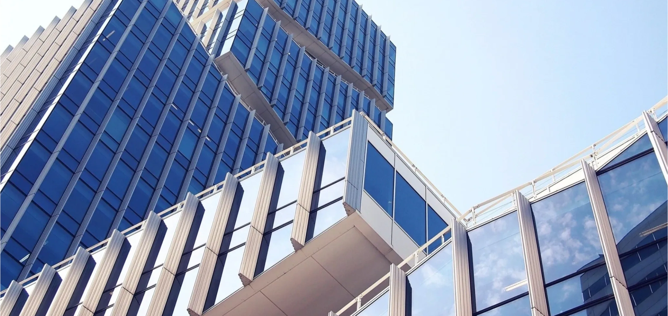 Modern glass office building with blue sky.