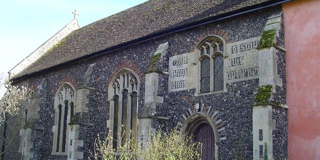 Historic stone church with arched windows and moss-covered walls.