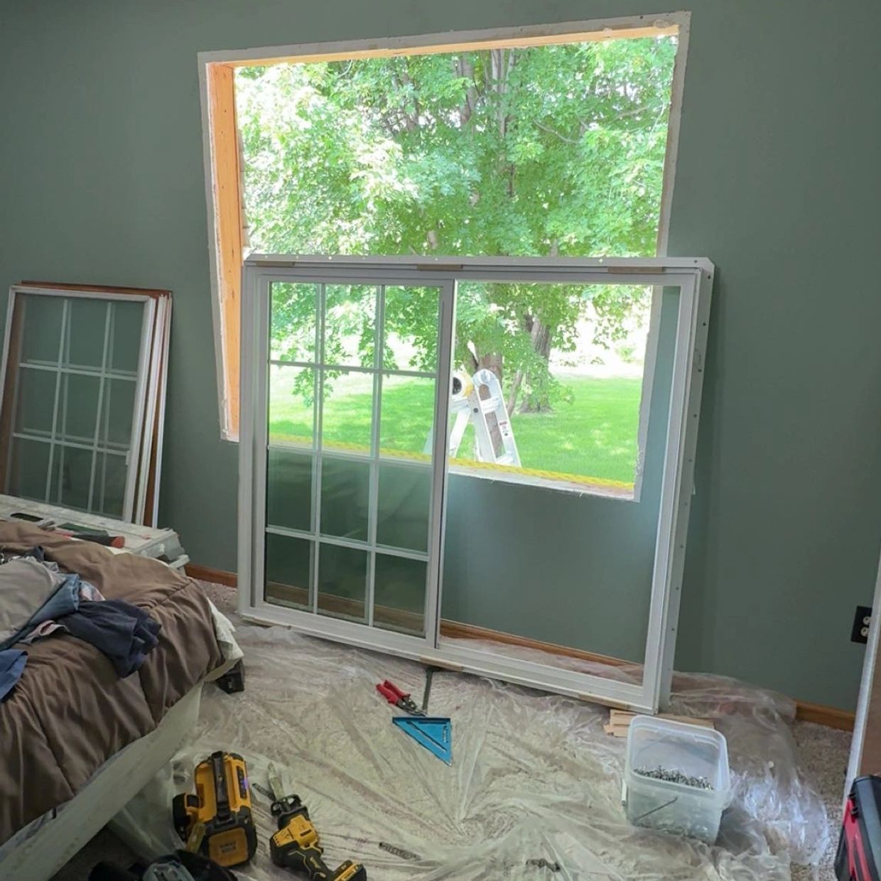 Window installation in progress with tools on the floor.