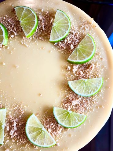 Creamy dessert topped with lime slices and crushed crumbs.