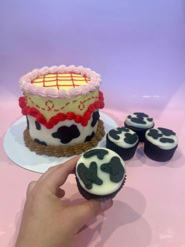 Cow-print cake with matching cupcakes.