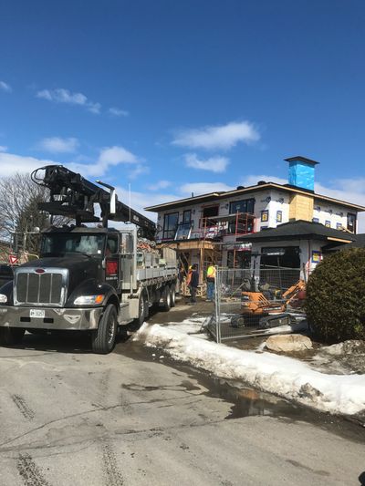 Truck and workers at a house under construction.