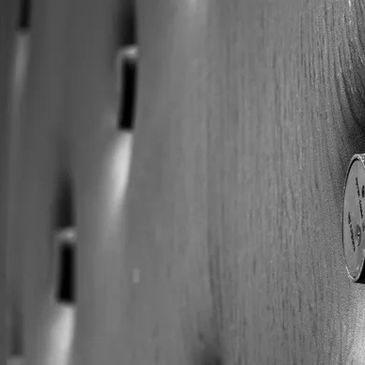 Close-up of a wooden surface with embedded black knobs or buttons.