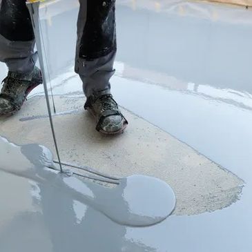 Worker applying a smooth, reflective epoxy floor coating.