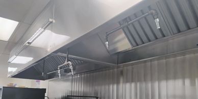 Commercial kitchen ceiling with ventilation and lighting fixtures.