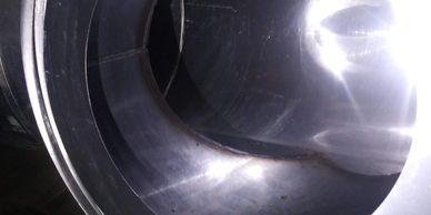 Close-up of a shiny metallic pipe interior reflecting light.
