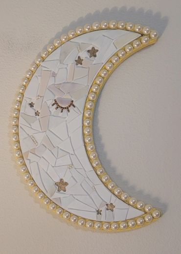 Decorative crescent moon wall art with pearls and stars.
