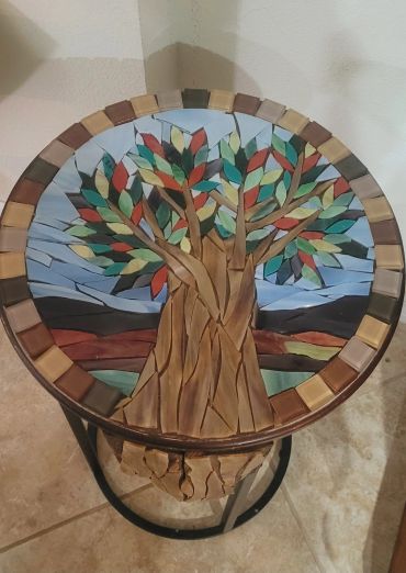 Round table with colorful tree mosaic.