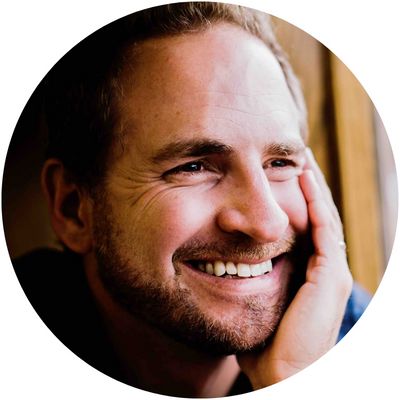 Confident man in a suit smiling while walking outdoors, showcasing fashion and style.