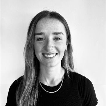 Young woman smiling in black and white portrait.