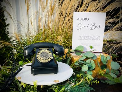 Vintage rotary telephone audio guest book surrounded by floral arrangements