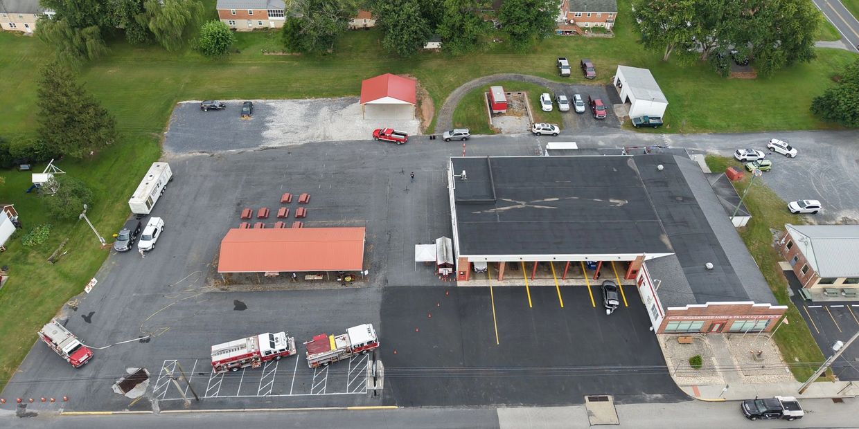 Aerial view of a fire station with fire trucks and parking area.