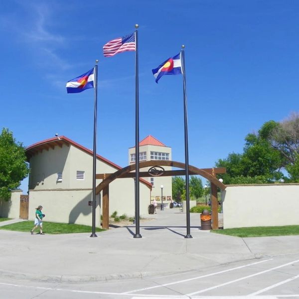Entrance with American and Colorado flags under a clear blue sky.