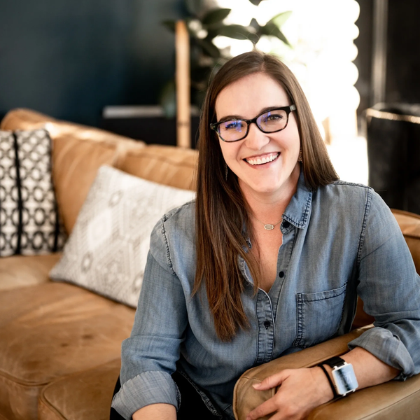 Woman smiling while sitting on a couch.