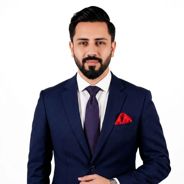 Man in navy blue suit with red pocket square, white shirt, and purple tie.