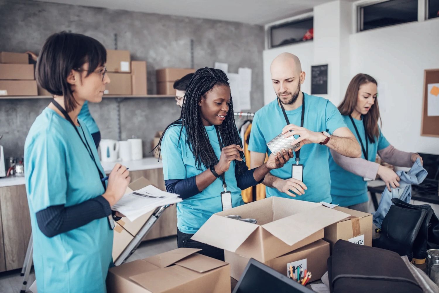 Black pencils in a gray holder next to a stack of white magazines with a camera in the background.