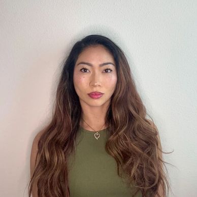 Woman with long wavy hair and green top.