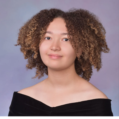 Young woman with curly hair in graduation attire.
