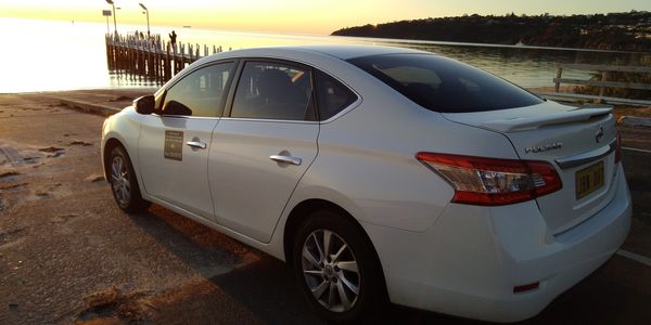 white car facing the beach front