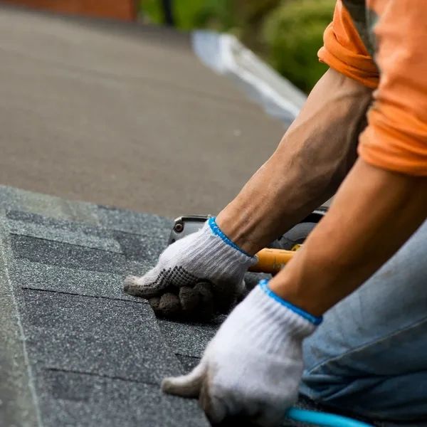 Roofer laying shingles.