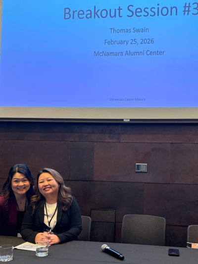 Two women at conference table with breakout session slide.