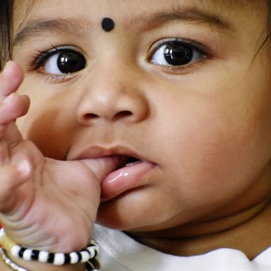 Close-up of a baby sucking their thumb, a habit needing specialized habit breaking for kids.
